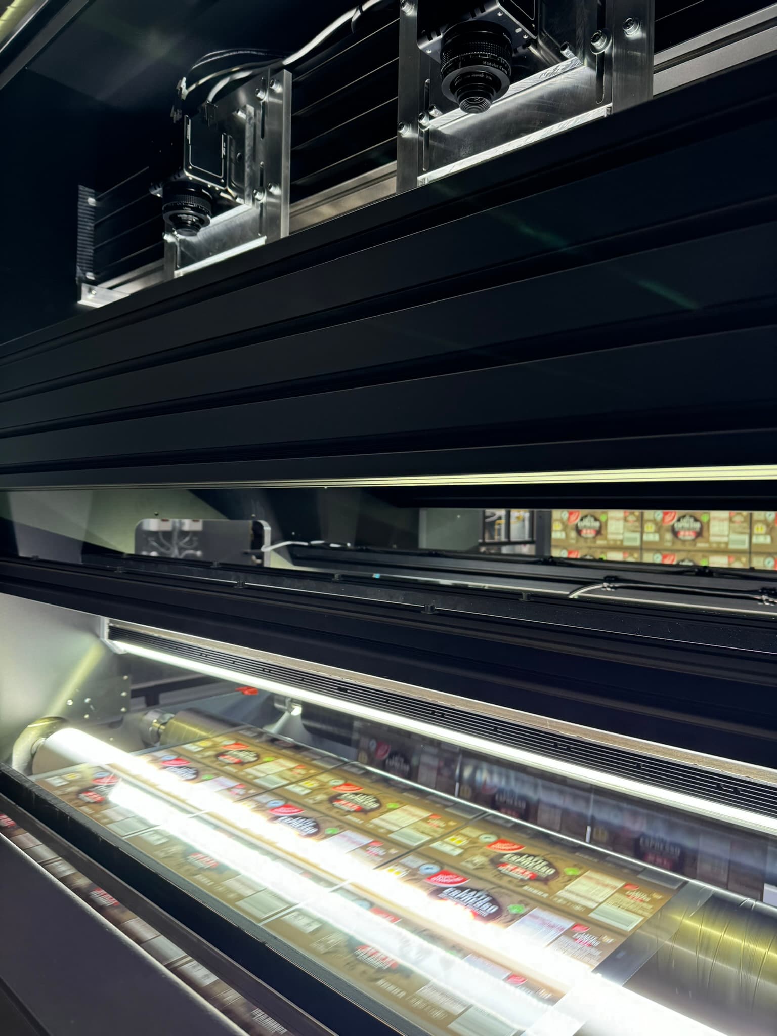 Camera and LED line over a press web showing labels in motion